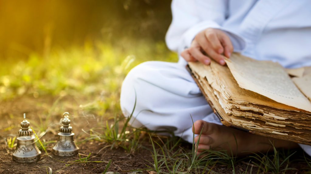 Buddhist,monk,sits,in,yoga,lotus,position,meditating,,reading,old