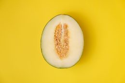 Creative,layout,made,of,melon.,melon,half,on,yellow,background.