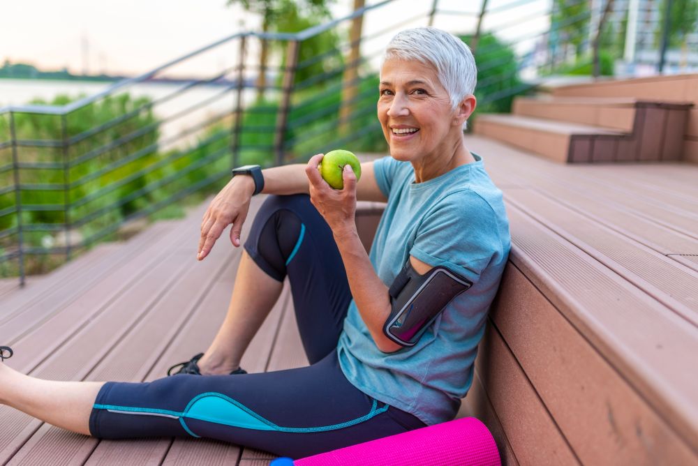 Sporty,woman,eating,apple.,beautiful,woman,with,gray,hair,in