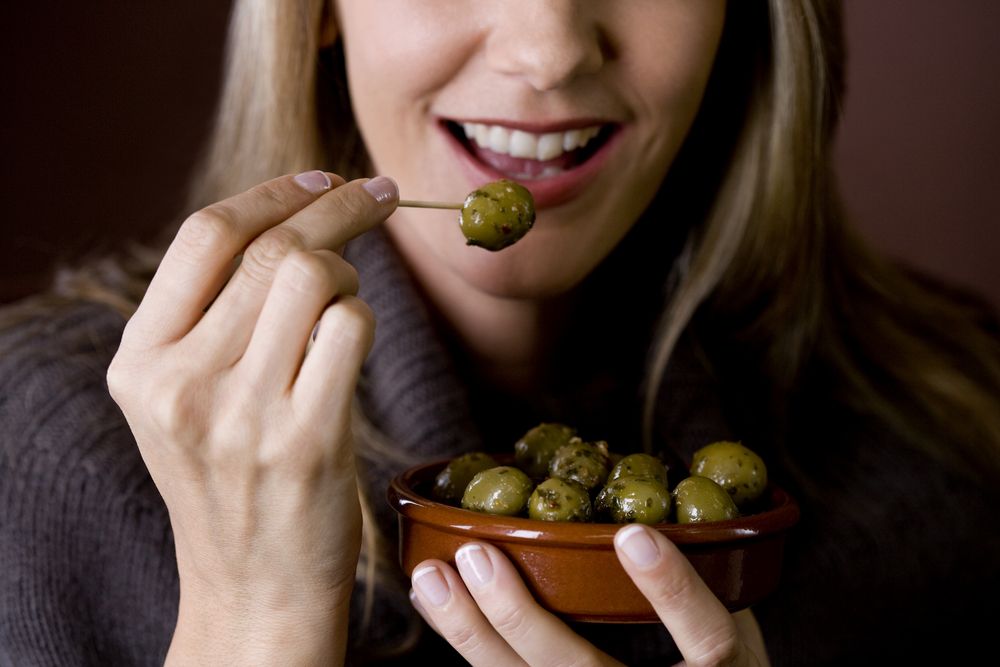 A,mid,adult,woman,eating,an,olive