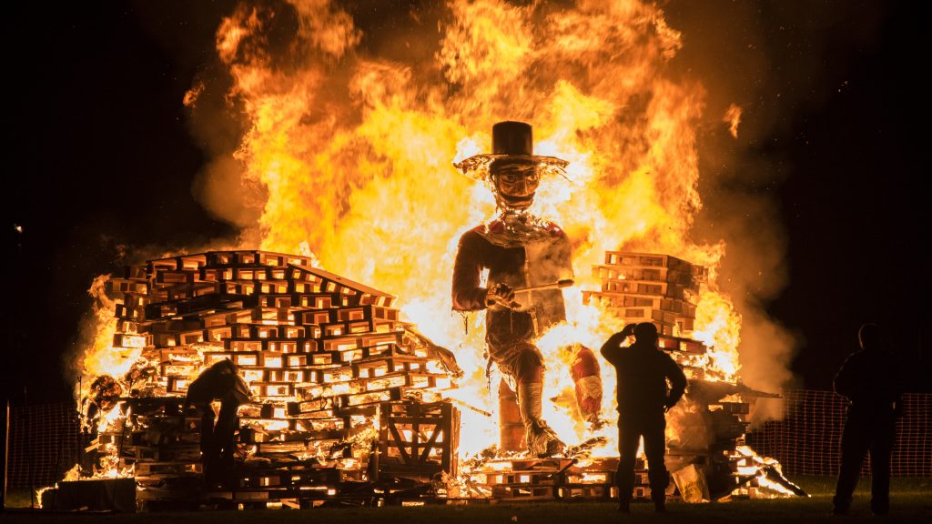 Man,standing,in,front,of,a,guy,fawkes,bonfire,during