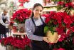 Friendly,female,flower,shop,owner,offering,blooming,potted,plants,poinsettias