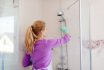 Young,woman,in,white,apron,cleaning,shower.,cleaning,service.,maid