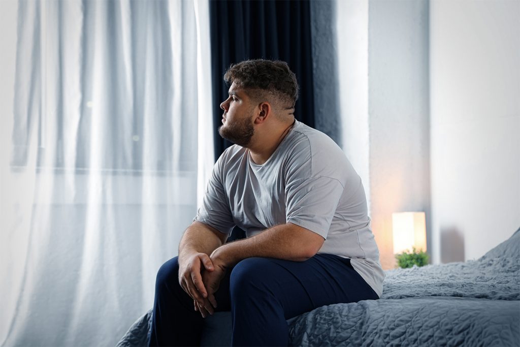 Túlsúlyos Férfi ül Az ágyon A Túlsúly Elleni Harc Világnapján