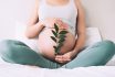 Pregnant,woman,holds,green,sprout,plant,near,her,belly,as