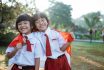 Two,indonesian,school,student,holding,flag,during,independence,day.,proud