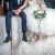 Beautiful,wedding,couple,sitting,on,wooden,pier,,swung,their,legs