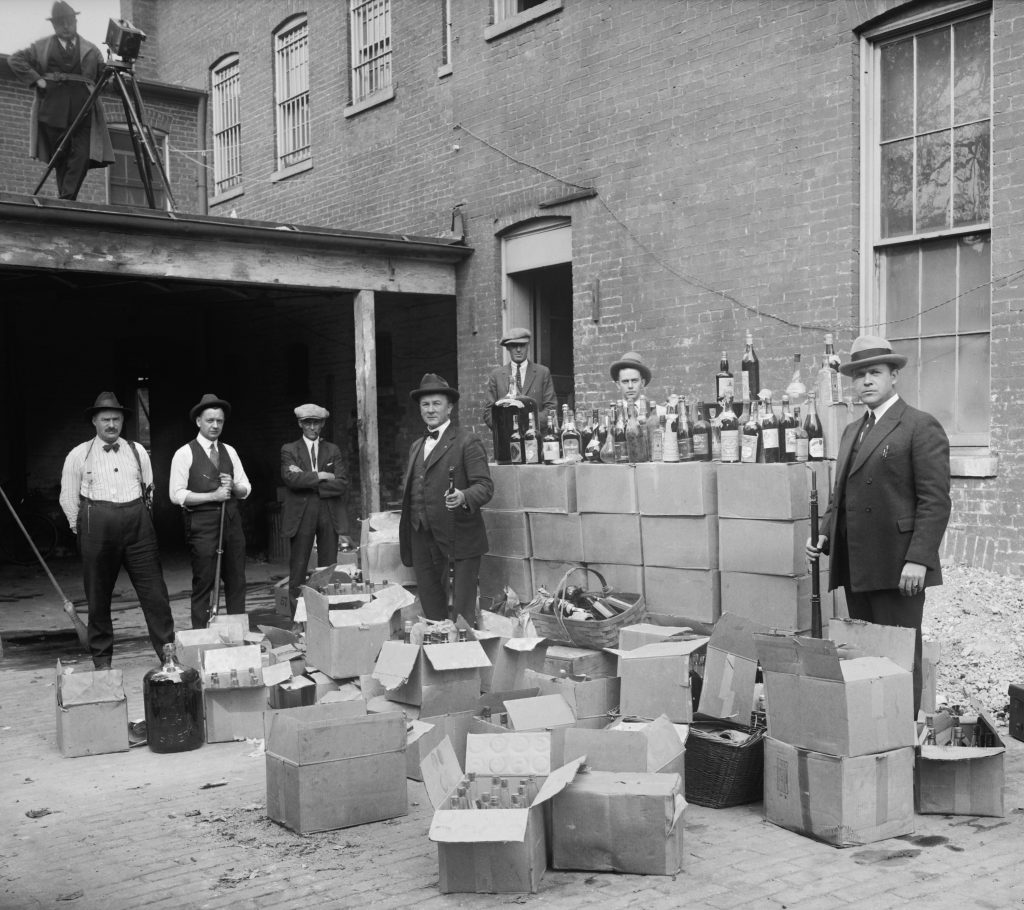 Prohibition,agents,stand,with,boxes,and,bottles,of,wine,and