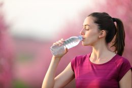 Runner,resting,drinking,water,from,a,bottle,after,sport,in