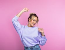 Happy Woman Dancing Against Pink Background