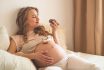 Pregnancy And Nutrition. Pregnant Woman Enjoying Donuts And Tea In Bed, Free Space