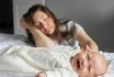 Tired Mother Sleeps Sitting On Floor Near Crying Baby Girl