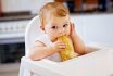 Portrait Of Cute Little Baby Girl Sitting In High Chair And Waiting For Feeding