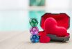 Dice Divination With Red Heart In Plastic Box Over Blurred Background