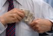 An Elegantly Dressed Man Puts A Wad Of Banknotes Into His Shirt Pocket