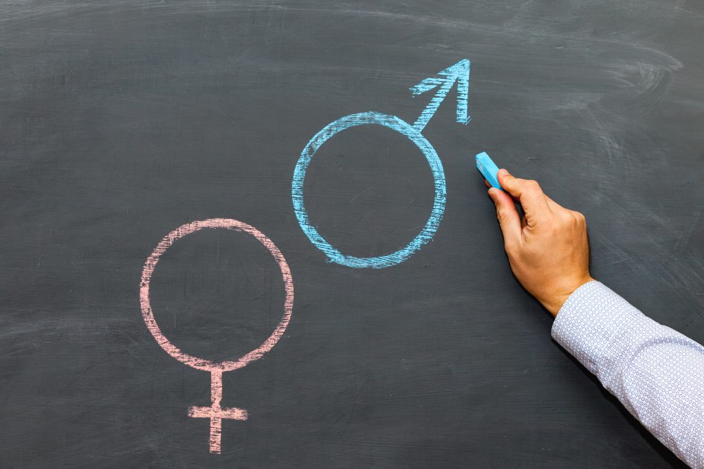 A Man's Hand With Chalk Draws A Male And Female Gender Symbol On A Chalkboard, The Concept Of Sexual Education