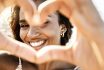 Close Up Image Of Smiling Woman In Swimwear On The Beach Making A Heart Shape With Hands Pretty Joyful Hispanic Woman Laughing At Camera Outside Healthy Lifestyle, Self Love And Body Care Concept