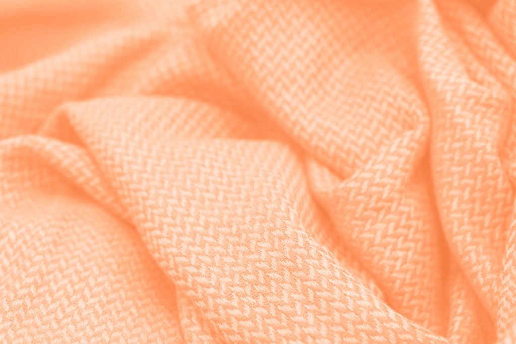 Folds Of Clothes Close Up, Concept Color Trend 2024 Peach Fuzz.