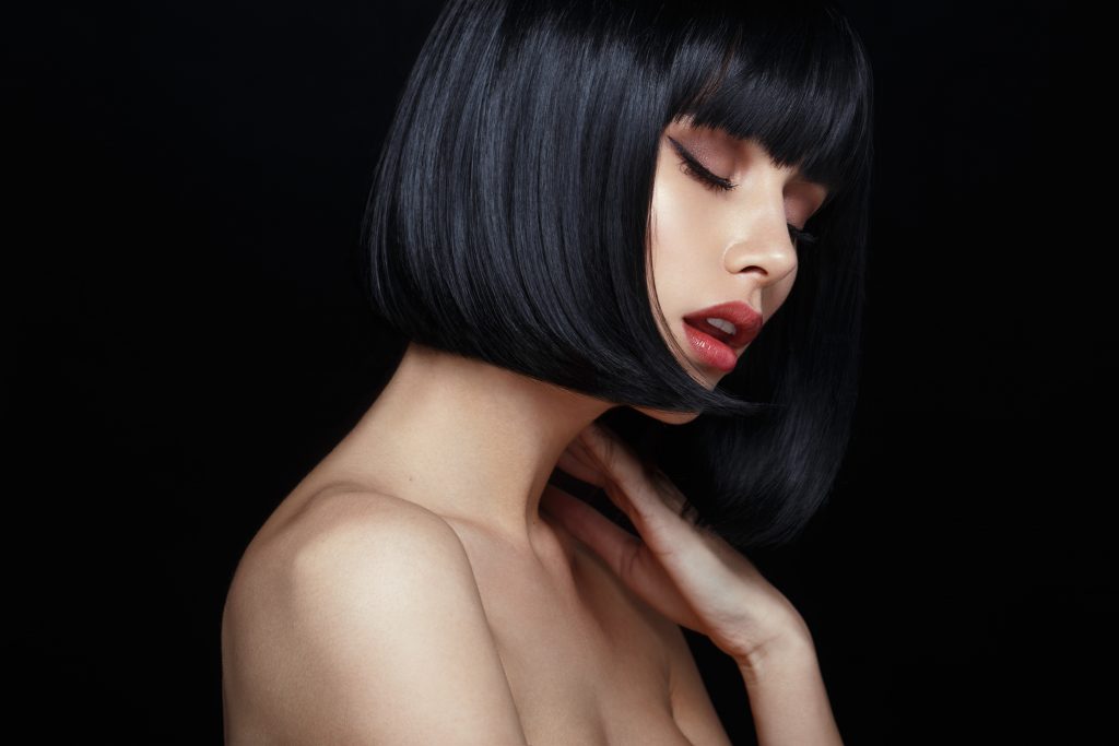 Profile Of A Sensual Model In Black Wig, Closed Eyes, Touches His Neck, Naked Shoulders, Isolated On Black Background.