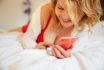 Woman Using Mobile Phone While Lying In Bed