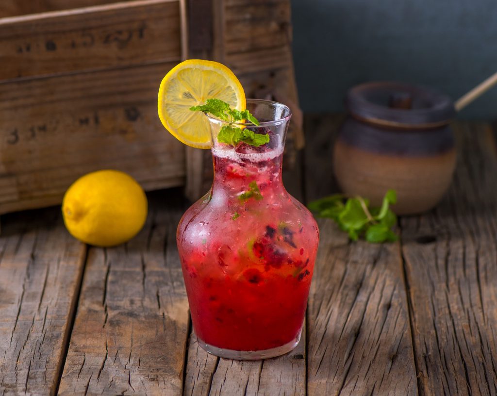 Fresh Healthy Sparkle Juice Raspberry Mojito Lemonade With Raw Fruit Served In Jar Isolated On Wooden Table Side View