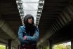 Young Depressed Homeless Girl Or Woman Standing Alone Under The Bridge On The Street On The Cold Weather Feeling Anxious Abandoned And Freezing Selective Focus