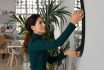 Close Up Smiling Woman Hanging Or Fixing Mirror, Decorating Apartment