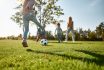 Where Family Fun Begins. Happy Family Playing With A Ball On Meadow