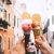 Beautiful And Delicious Italian Gelato In Waffle Cone In Front Of Streets And Bridges Of Venice.