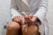 Woman Holds A Tampon In Toilet