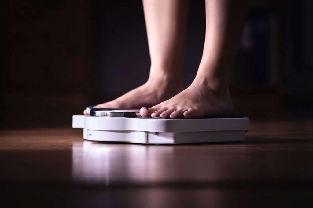 Feet On Scale. Weight Loss And Diet Concept. Woman Weighing Herself. Fitness Lady Dieting. Weightloss And Dietetics.