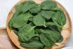 Leaves Of Fresh Spinach On A Round Wooden Plate. View From Above.