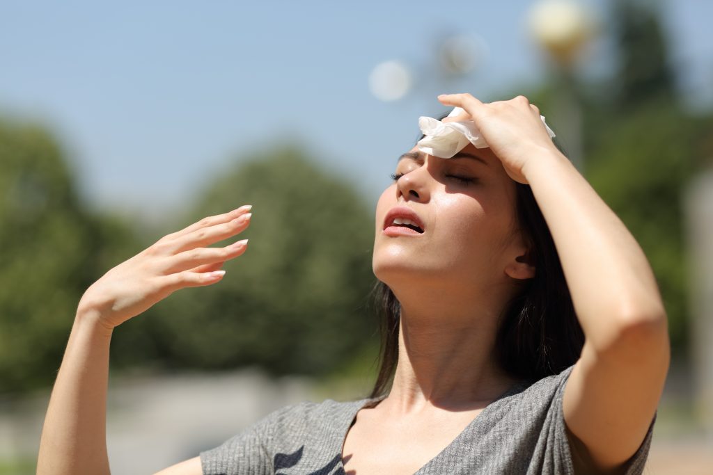 Asian Woman Drying Sweat In A Warm Summer Day