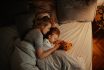 Loving Mother And Daughter Sleeping Together In Bed In The Evening