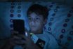 Child In Bed At Night With A Book And A Smartphone In The Dark. Concept Of Problems With Mobile Addiction At Young Ages. Child With Sleeping Problems And Insomnia Due To The Use Of Electronic Devices