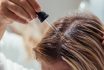 Woman Applies Oil To Her Hair With Pipette. Beauty Caring For Scalp And Hair.