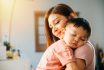 A Tender Loving Biracial Mother Cradles Her Small Sleeping Newborn In Her Arms