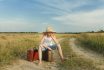 Teenage Traveler Waiting And Sitting On Luggage