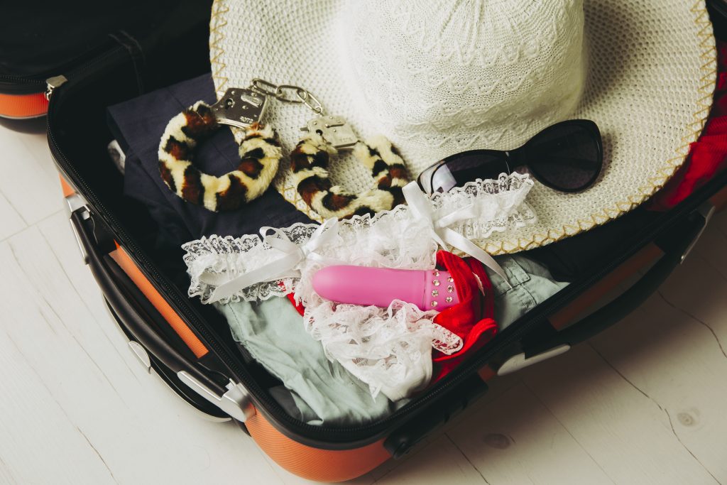 Traveling With Sex Toys Concept. Packing Sex Toys In Luggage Suitcase When Going On Trip.