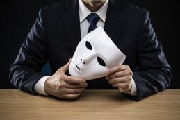 Man In A Suit Removes His Mask