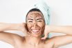 Young Smiling Woman Applying Coffee Scrub Mask On Face Happy Girl Having Skin Care Spa Day At Home Healthy Alternative Natural Exfoliation Treatment And People Lifestyle Concept