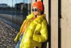 Stylish Girl Wearing Yellow Puffer And Orange Knitted Hat