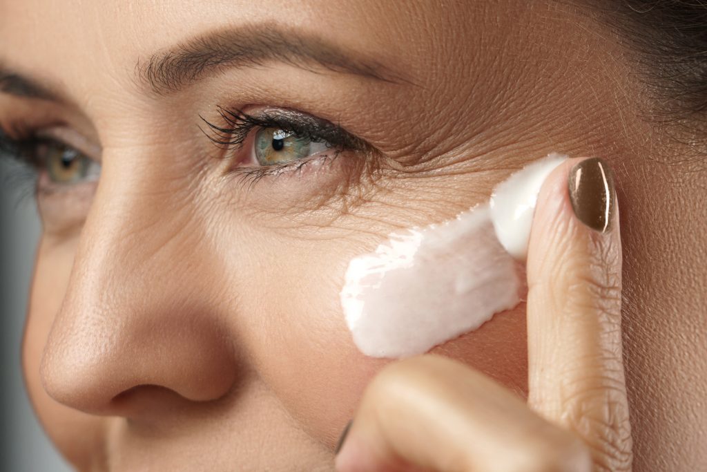 Middle Aged Woman Applying Anti Aging Cream On Her Face