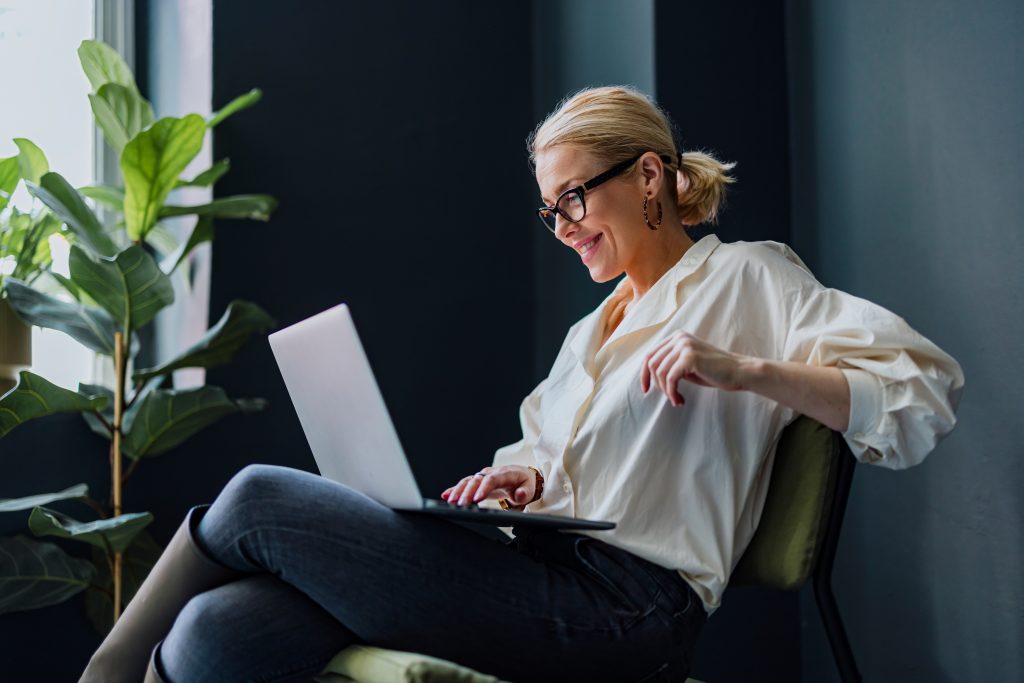 Happy Business Woman Using Laptop Computer In The Office