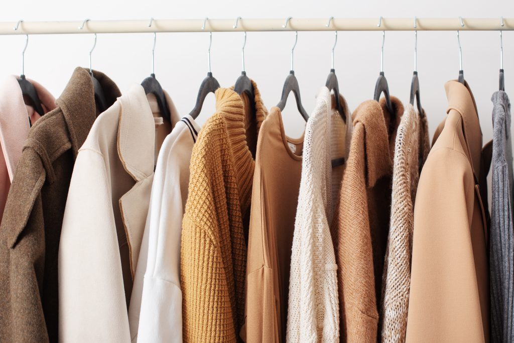 Female Autumn Clothes On Hangers In White Room