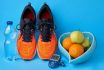 Orange Sneakers, Glucometer, Bottle Of Drinking Water And Fruits On Blue Background