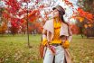 Stylish Woman Wears Yellow Sweater Holding Handbag In Autumn Park. Fall Female Clothes And Accessories. Fashion