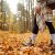 Woman's Legs In Boots In Autumn Foliage. Leaf Fall.