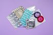 Contraceptive Pills, Condoms And Intrauterine Device On Violet Background, Flat Lay. Different Birth Control Methods