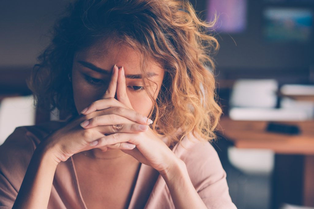 Tired Young Woman Leaning Head On Hands